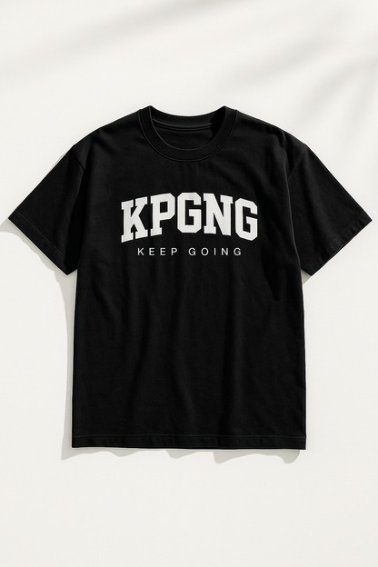 Black t-shirt laid flat on a white background with natural shadows. Features bold KPGNG logo and 'Keep Going' text across the chest.