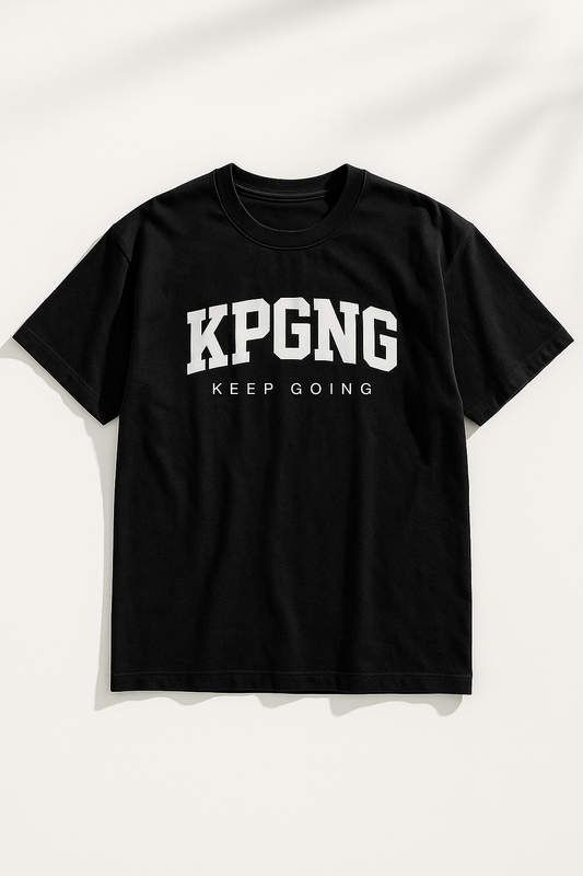 Black t-shirt laid flat on a white background with natural shadows. Features bold KPGNG logo and 'Keep Going' text across the chest.
